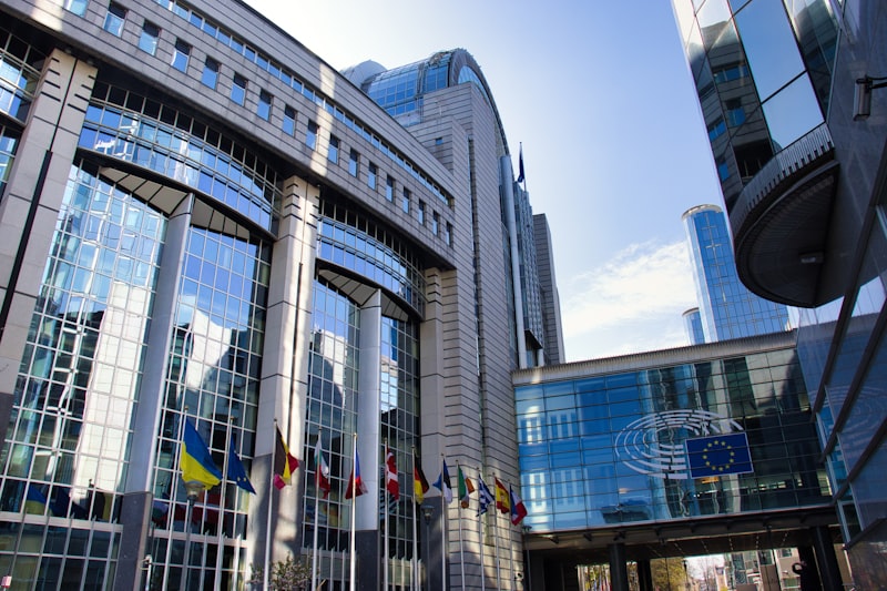Prédio da Comissão Europeia com bandeiras da União Europeia, representando a fiscalização da lei de IA