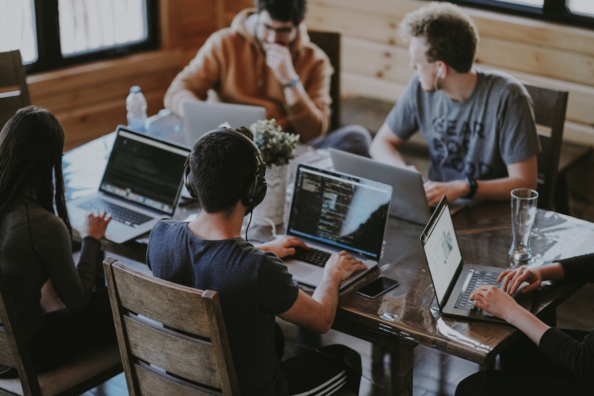 Grupo de pessoas trabalhando juntas em laptops em ambiente de escritório